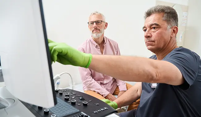 senior man and medical professional reviewing monitor