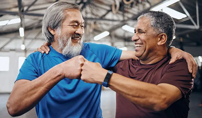 two middle age men fist bumping after exercise